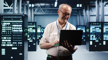 Capable serviceman expertly managing data while navigating in industrial server room. Proficient...