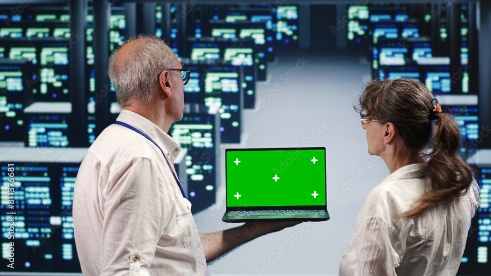 Aufkleber experienced professionals looking around high tech data center, using mockup laptop to crosscheck di