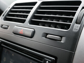 Car dashboard close-up, blurring and defocusing. Ventilation systems in the car. Car air conditioning system grid panel on front console.