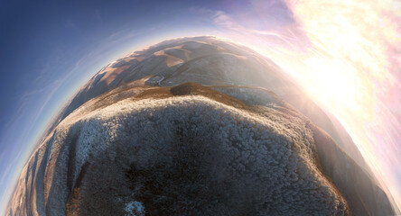 drone flies over the peaks of the mountainous Carpathian region with a winter color pattern of snowy beech trees on the tops, river valleys painted with sunset flames Spherical 360 panorama
