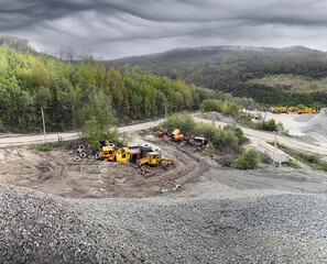 Carpathian Mountains of Ukraine, a quarry where granite sandstone is mined for the production of building materials, powerful trucks and conveyors load gravel - video from a drone