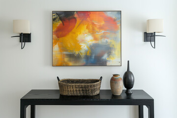 A large framed colorful abstract painting is hanging on the wall above a black console table with two lamps. There are also some vases and baskets sitting on top of it.