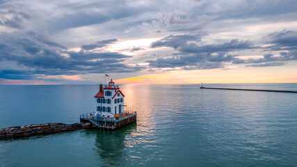 Lorain harbor lighthouse in the middle of lake Erie, under evening light.