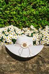 A white sun hat next to white flowers in Girona spring festival. Temps de flors 2024