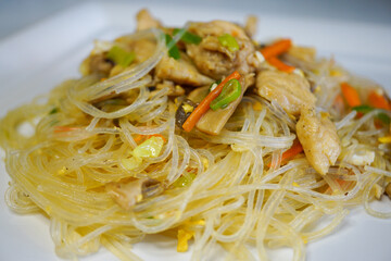 glass noodles with chicken and vegetables - stir fried glass noodles on white plate