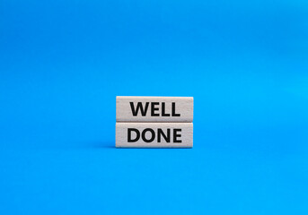 Well done symbol. Wooden blocks with words Well done. Beautiful blue background. Business and Well done concept. Copy space.