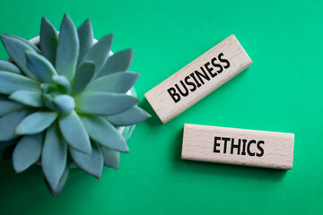 Business ethics symbol. Concept word Business ethics on wooden blocks. Beautiful green background...
