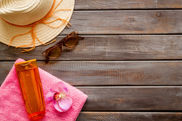 Summer holiday beach background. Female straw hat with sunscreen and sunglasses, top view
