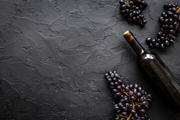 Wine concept with bottle of red wine and bunch of grapes
