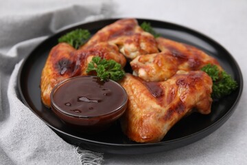 Fresh marinade and chicken wings on light table, closeup