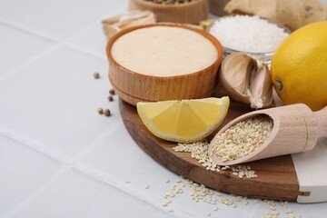 Fresh marinade and different ingredients on white tiled table. Space for text