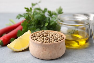 Aromatic peppercorns and different fresh ingredients for marinade on grey table