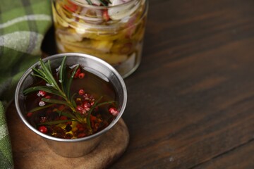 Tasty fish marinade with rosemary in bowl on wooden table, closeup. Space for text