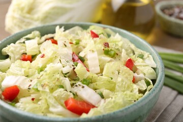 Tasty salad with Chinese cabbage in bowl on table, closeup