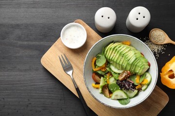 Healthy dish high in vegetable fats served on black wooden table, flat lay. Space for text