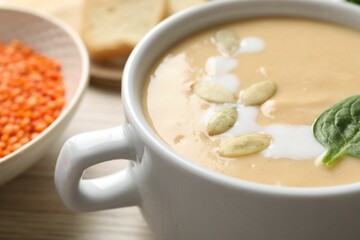 Healthy cream soup high in vegetable fats on wooden table, closeup