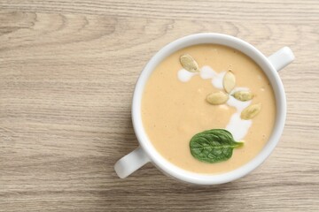 Healthy cream soup high in vegetable fats on wooden table, top view. Space for text