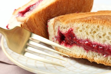 Round croissant with jam on table, closeup. Tasty puff pastry