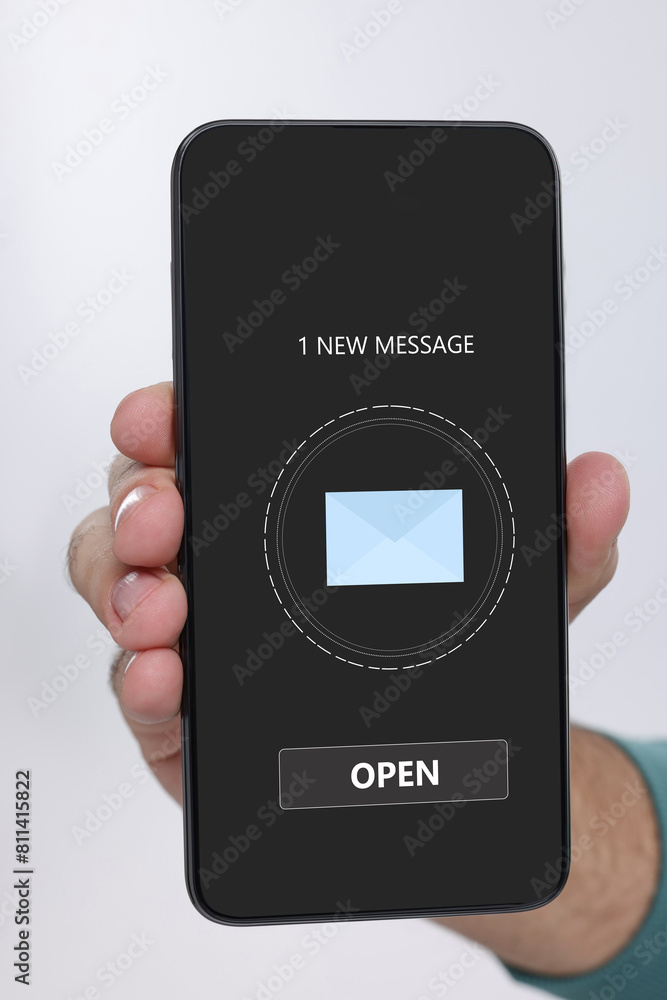Poster man showing mobile phone with new message notification on screen against white background, closeup