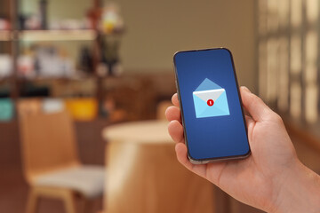 Man received message on mobile phone in cafe, closeup. Envelope illustration on device screen
