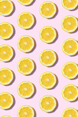 Pattern made of lemon fruit. Summer aesthetic pink background concept.
