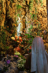 植物に囲まれた像に祈りをささげる人の像