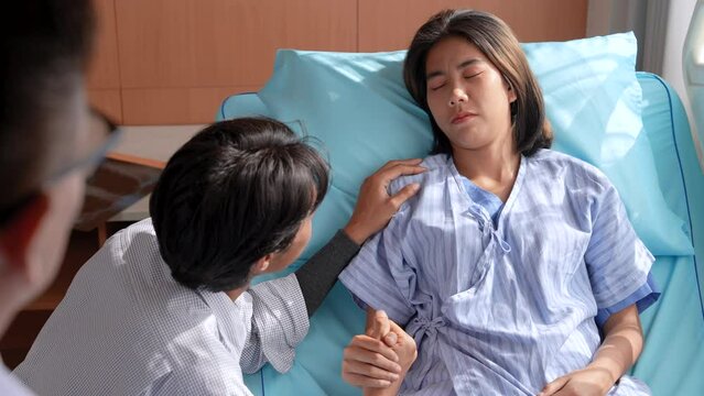 Asian medical obstetrician doctor diagnosis examines reports using tablet for threatened miscarriage symptoms to patient woman while husband holding hands and accepts treatment procedure recovery