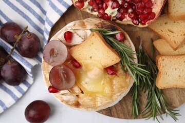 Flat lay composition with tasty baked camembert on white tiled table