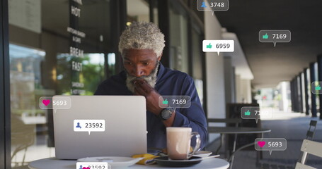 Middle-aged African American chef/restaurant owner using laptop at cafe