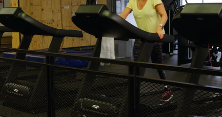 Caucasian senior coach training on treadmill in a gym