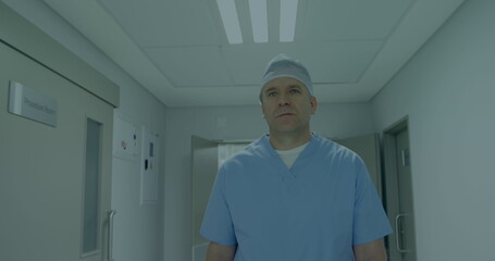 A middle-aged Caucasian male, doctor, standing in a hallway
