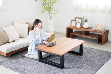 Wide angle of a young woman with a pretty smile taking care of her skin in her room or living room