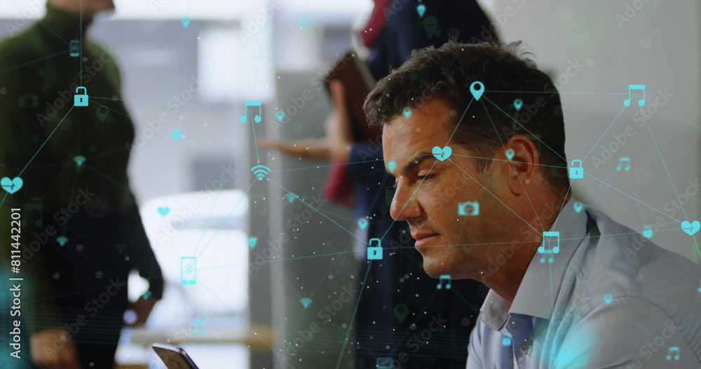 Poster image of icons connected with lines over caucasian man scrolling on smartphone in office