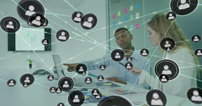 Image of icons connected with lines over diverse coworkers discussing reports on laptop