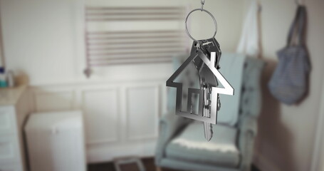 Image of silver key and house key ring over blurred house interior
