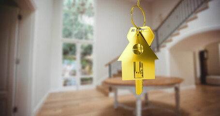 Image of gold key and key ring over blurred house interior