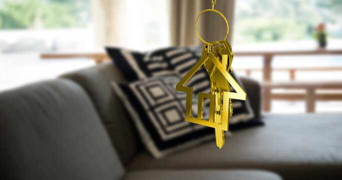 Image of gold key and house key ring over blurred house interior