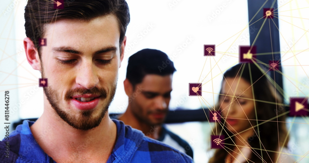 Canvas Prints Image of two globes of digital icons over caucasian man smiling while using smartphone at office