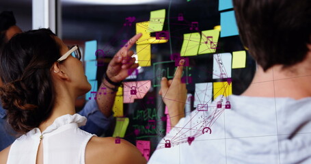 Image of data processing over diverse business people taking notes on glass wall