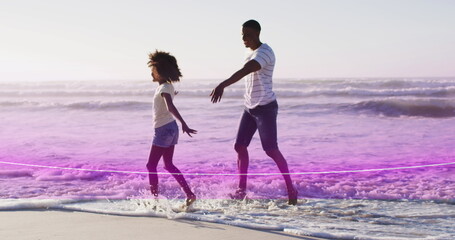 Image of light trail over african american couple at beach