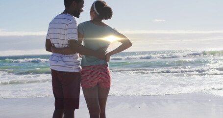 Fototapeta premium Image of light trails over african american couple at beach