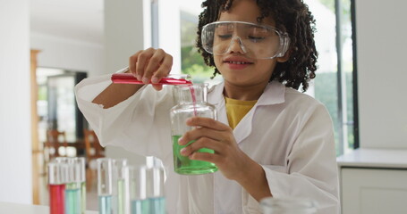 Image of shapes over african american schoolboy at science class