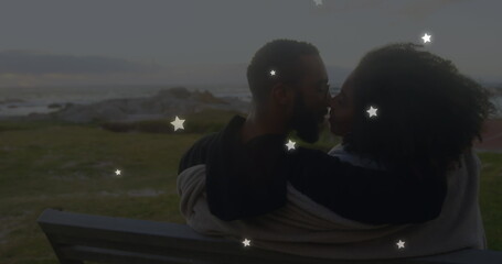 Image of stars over diverse couple embracing