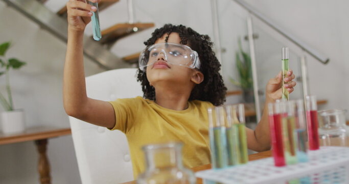 Image of shapes over african american schoolboy at science class