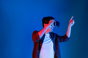 Smart Asian man looking through VR glasses turn to metaverse pointing slide research folder data with touchscreen in futuristic technology analyzing innovation interface 3D hologram meta. Contrivance.