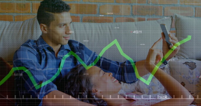 Image of graph and changing numbers, diverse couple watching images on cellphone at home