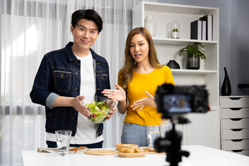 Cooking show on live streaming with two chef influencers teaching mixed salad with dressing for...