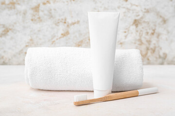 Bamboo toothbrush, paste and clean towel on light table