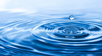 Drop of water falls into body of water, creating ripple effect. Concept of calmness and tranquility