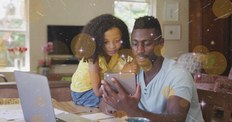 Image of light and dots moving over happy african american father and daughter using tablet